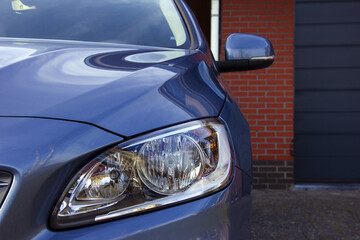 Poster - Headlight of a modern luxury blue car