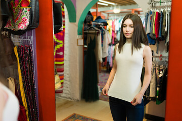 Beautiful woman buying second hand clothes