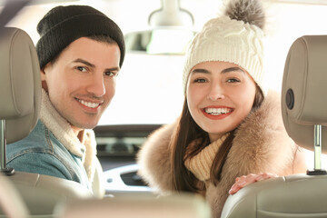 Poster - Happy couple sitting in car on winter day