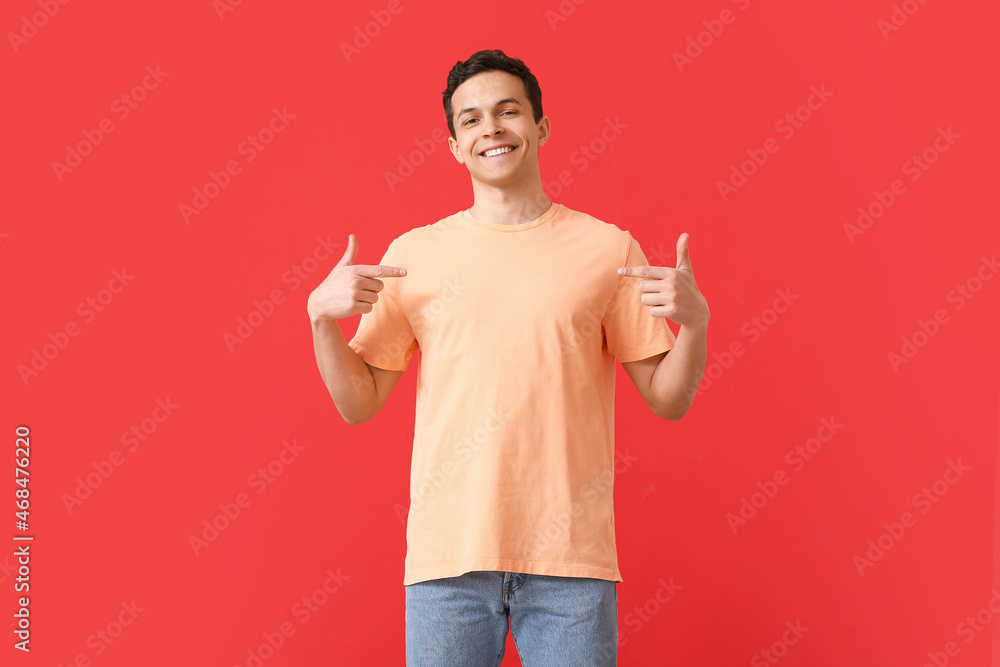Handsome young man in stylish t-shirt on color background