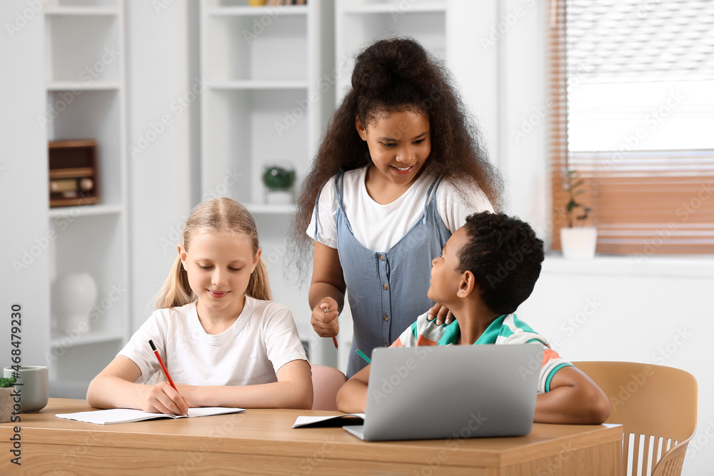 Little schoolchildren studying online at home