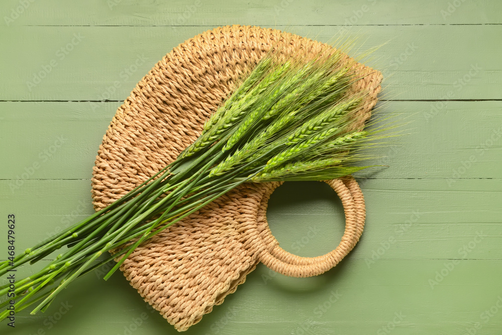 Green wheat spikelets and bag on wooden background