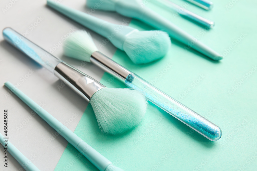 Beautiful makeup brushes on color background, closeup