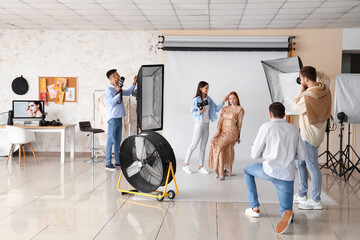 Poster - Young photographers taking picture of model in studio