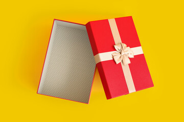 Opened red Christmas gift box on color background