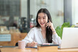 © amnaj - Beautiful young Asian businesswoman charming smiling and talking on the mobile phone in the office..