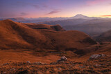 Fototapeta Tęcza - Autumn mountains at sunset. Mount Elbrus in the background. In front of the valley with fog.