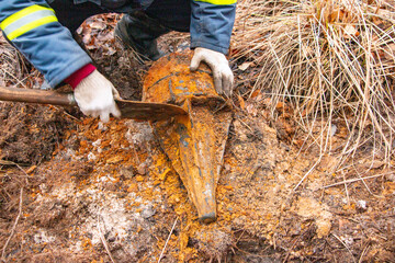 Wall Mural - Man hands keep old iron fragments, clean them from dirt, clay, land and rust, after searching and producing scrap metal in forest.