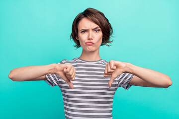 Wall Mural - Photo of young girl unhappy upset show thumb-down bad quality dislike isolated over teal color background