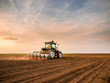 Leinwandbild Motiv Tractor drilling seeding crops at farm field. Agricultural activity.