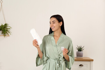 Wall Mural - Young woman with menstrual cup and pad at home