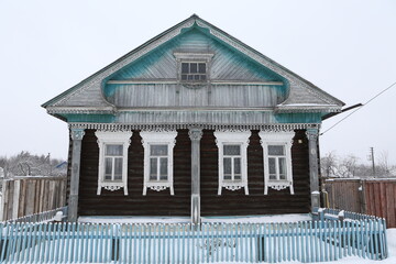 Wall Mural - Vintage wooden rural house in Maydakovo village in Ivanovo region, Russia. Building facade; ornamental windows with carved frames. Russian traditional national folk style in architecture. Countryside