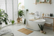 © New Africa - Stylish bathroom interior with modern tub, houseplants and beautiful decor. Home design