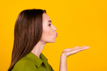 Sticker - Photo of charming cute young woman dressed green shirt sending kiss arm empty space isolated yellow color background