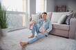 Relaxed positive casual korean man sit floor enjoy rest weekend indoors