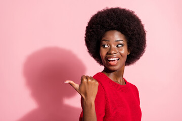 Sticker - Photo of attractive impressed dark skin girl look indicate thumb empty space isolated on pink color background