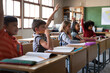 © Wavebreak Media - Group of multi ethnic kids sitting on their desk in the classroom at school. Primary education socia