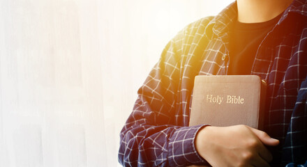 young woman hugging bible and praying to god faith forgiveness