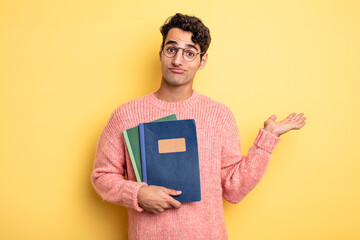 Wall Mural - young handsome man feeling puzzled and confused and doubting. notebook concept