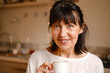 © ADDICTIVE STOCK - Smiling woman drinking coffee in morning