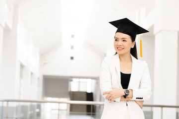 Wall Mural - Female doctoral graduates wearing yellow tassel black graduation caps are at the university.