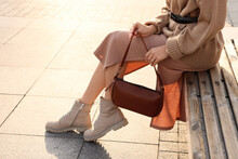Fashionable Woman With Stylish Bag On Bench Outdoors, Closeup