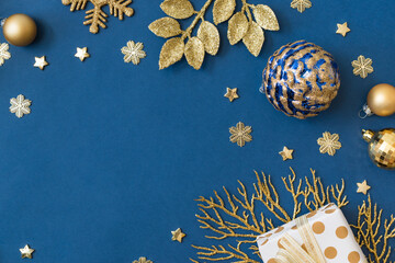 Wall Mural - Christmas holiday composition. Flat lay frame with christmas balls and gift box on a blue background