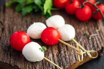 canapes mozzarella and tomato caprese salad on a skewer meal snack on the table copy space food background rustic. top view keto or paleo diet veggie vegan or vegetarian food