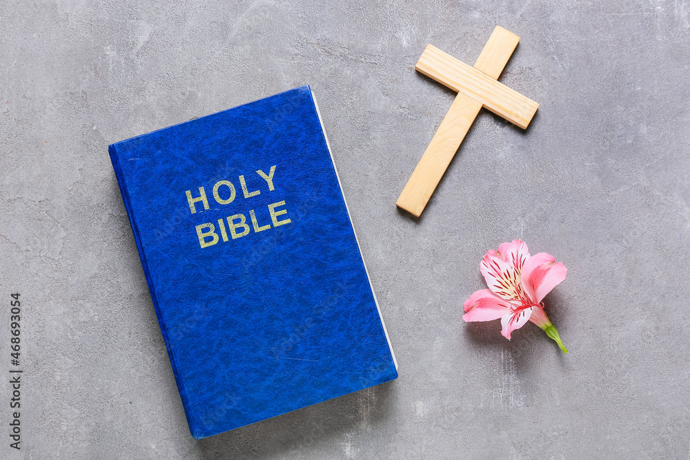 Blue Holy Bible with cross and flower on grunge background