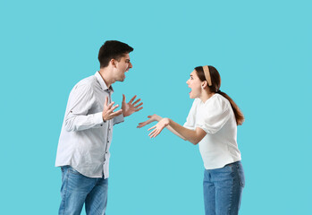 Poster - Young couple quarreling on blue background