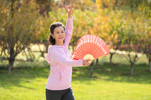 Senior Chinese Woman Practicing Tai Chi In The Park