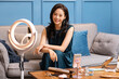 © Blue Jean Images - Young Chinese woman doing live webcast at home