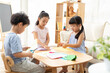© Blue Jean Images - Cute Chinese children doing paper craft in living room