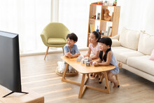 Cute Chinese Children Watching TV In Living Room
