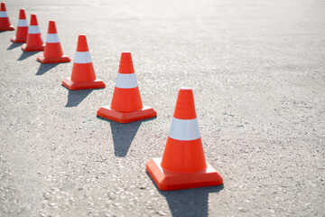 a row of traffic orange cones put on the highway as the sign of work is in progress