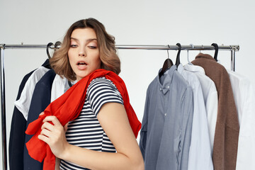 Wall Mural - cheerful woman selection of clothes near the wardrobe light background