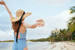 cheerful woman in a beach hat by the ocean island summer