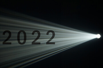 Wall Mural - light beam from spotlight or projector texture and black background with 2022 word - happy new year 
