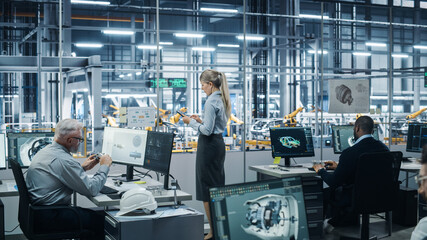 Fototapete - Car Factory Office: Team of Automotive Engineers Working, Using Computers to Design Advanced 3D Models for High-Tech Engines. Automated Robot Arm Industrial Assembly Line Manufacturing Vehicles