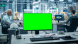 © Gorodenkoff - Car Factory: On the Desk Green Screen Chroma Key Computer. In Background Diverse Team of Engineers Work in Office of Automated Robot Arm Assembly Line Manufacturing Vehicles