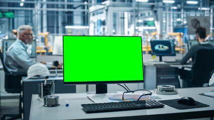 Canvas Print - Car Factory: On the Desk Green Screen Chroma Key Computer. In Background Diverse Team of Engineers Work in Office of Automated Robot Arm Assembly Line Manufacturing Vehicles