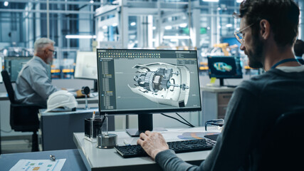 Canvas Print - Car Factory Office: Engineer Working on Turbine Prototype on Computer, Design Advanced 3D Model for High-Tech Green Energy Electric Engine. Automated Robot Arm Assembly Line Manufacturing Facility