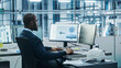 © Gorodenkoff - Car Factory Office: Black Engineer Working on Desktop Computer, Screens Show CAD Software with 3D Component, Monitoring of Automated Robot Arm Assembly Line Manufacturing High-Tech Electric Vehicles