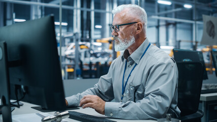 Fototapete - Car Factory Office: Portrait of Male Engineer Working on Computer. Automated Robot Arm Assembly Line Manufacturing Electric Vehicles. Technician Monitoring Electronics Production Conveyor.