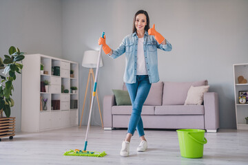 Full length photo of brunette young cute lady wash floor show thumb up wear jeans shirt sneakers gloves at home alone