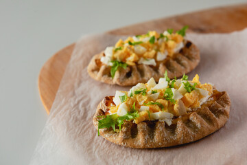 Wall Mural - Karelian rice pies served with chopped boiled eggs on the table.