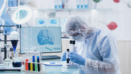 Wall Mural - Scientist researcher doctor analyzing blood slide using medical microscope developing vaccine against coronavirus during biochemistry experiment in hospital laboratory. Medicine concept