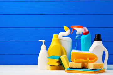 Various cleaning items against blue wooden background