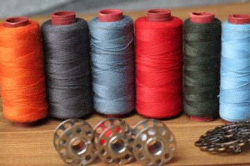 sewing threads of various colors on a wooden table