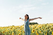 © Patricia - beautiful 40 year old woman breathing fresh air in sunflower field with open arms and sunglasses